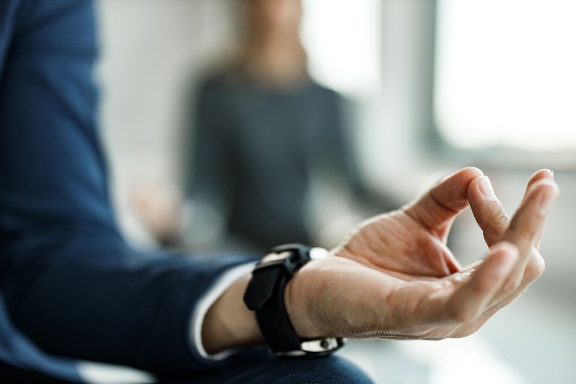 Close up of a businessman exercising Yoga in Lotus position.